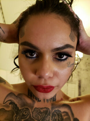 Tatted nymph Genevieve Sinn sports crimson lips during a